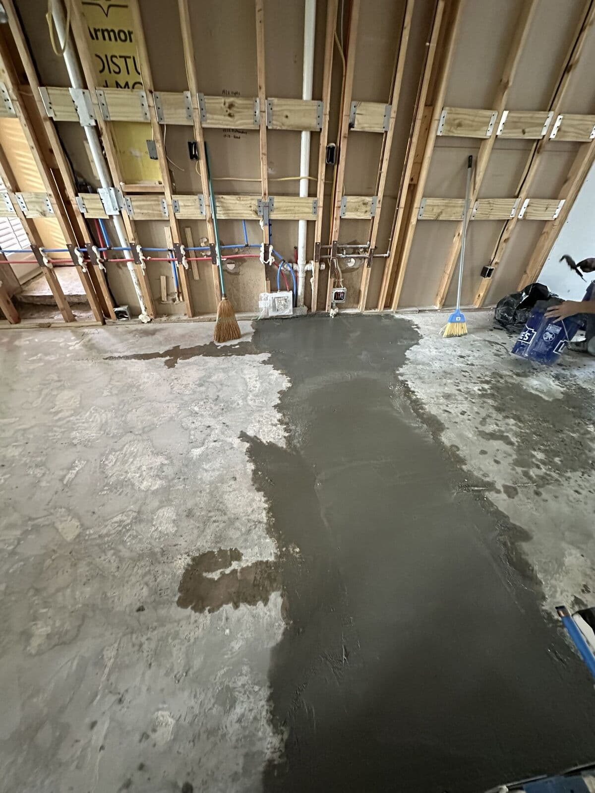 Fresh concrete being poured into the trenched section of the floor